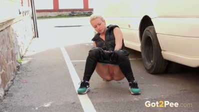 Sexy hot blonde pulls down her leather leggings and pees in a parking lot