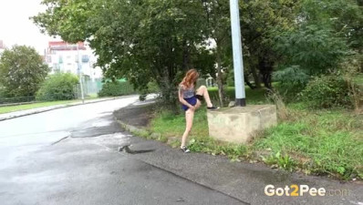 Lovely redhead lifts her legs to pee on the street