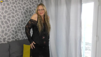 Mature lady in a black dress toying her vagina