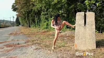 Dark hair hottie enjoys peeing on a deserted road