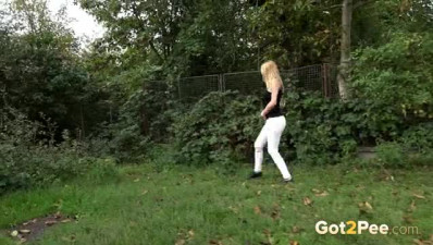 Stunning hot babe hides by the bushes so she can take a long pee