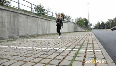 Sexy blonde in sneakers peeing by the roadside